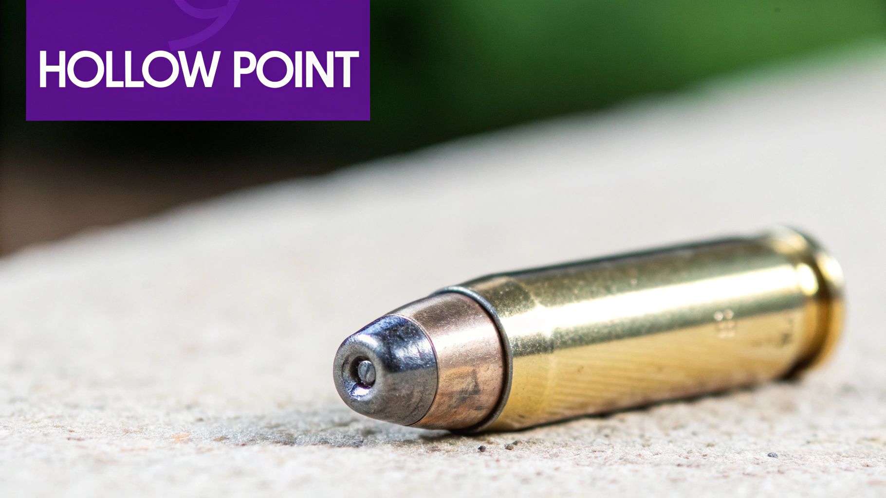 Hollow point ammunition bullet lying on concrete surface showing distinctive cavity design